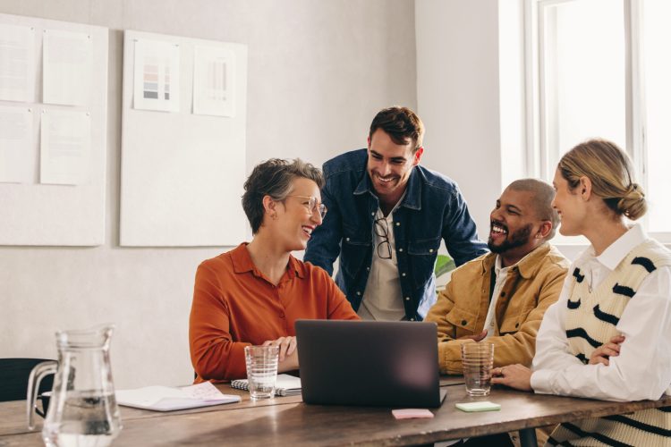 Cheerful designers smiling happily while having a meeting in an office. Group of successful businesspeople working on a new interior design project in a creative workplace.